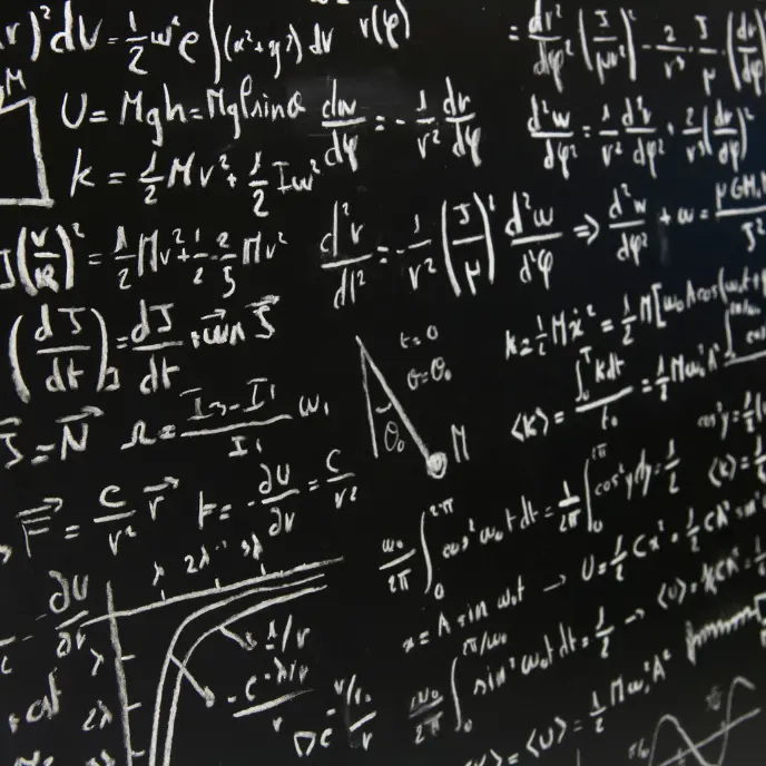 Lavagna con formule e calcoli della fisica quantistica